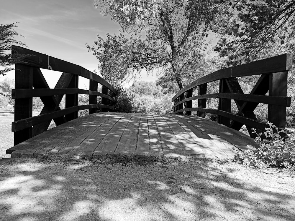 a black and white photo of a wooden bridge