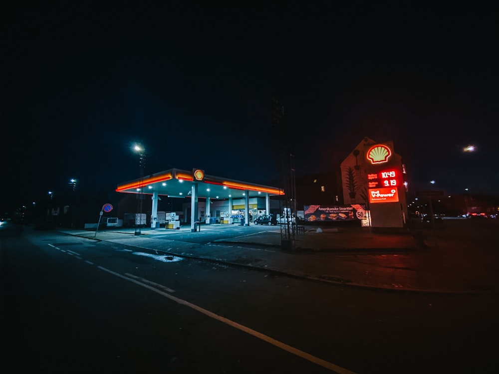 a gas station lit up at night time