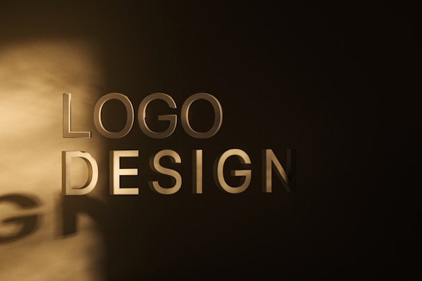 The image features the words 'LOGO DESIGN' in large, bold letters against a dark background, with a spotlight creating a shadow effect on the wall.