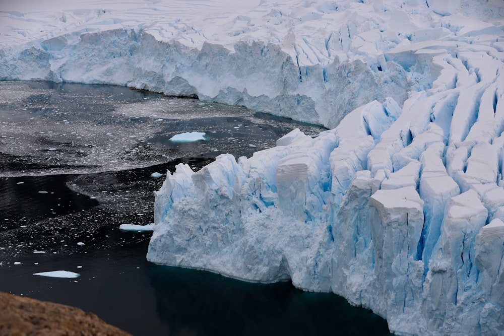 un grand iceberg flottant à côté d’un plan d’eau