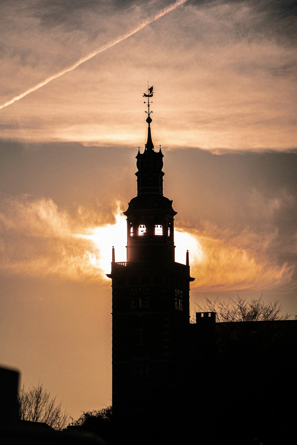 the sun is setting behind a clock tower