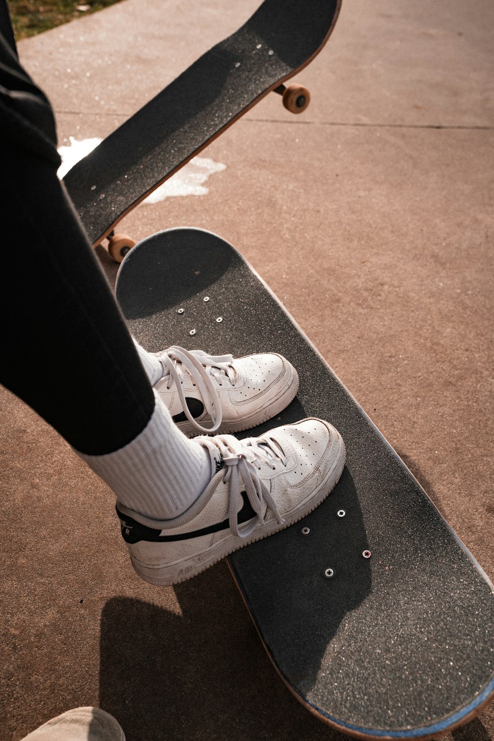 a person standing on top of a skateboard on a sidewalk