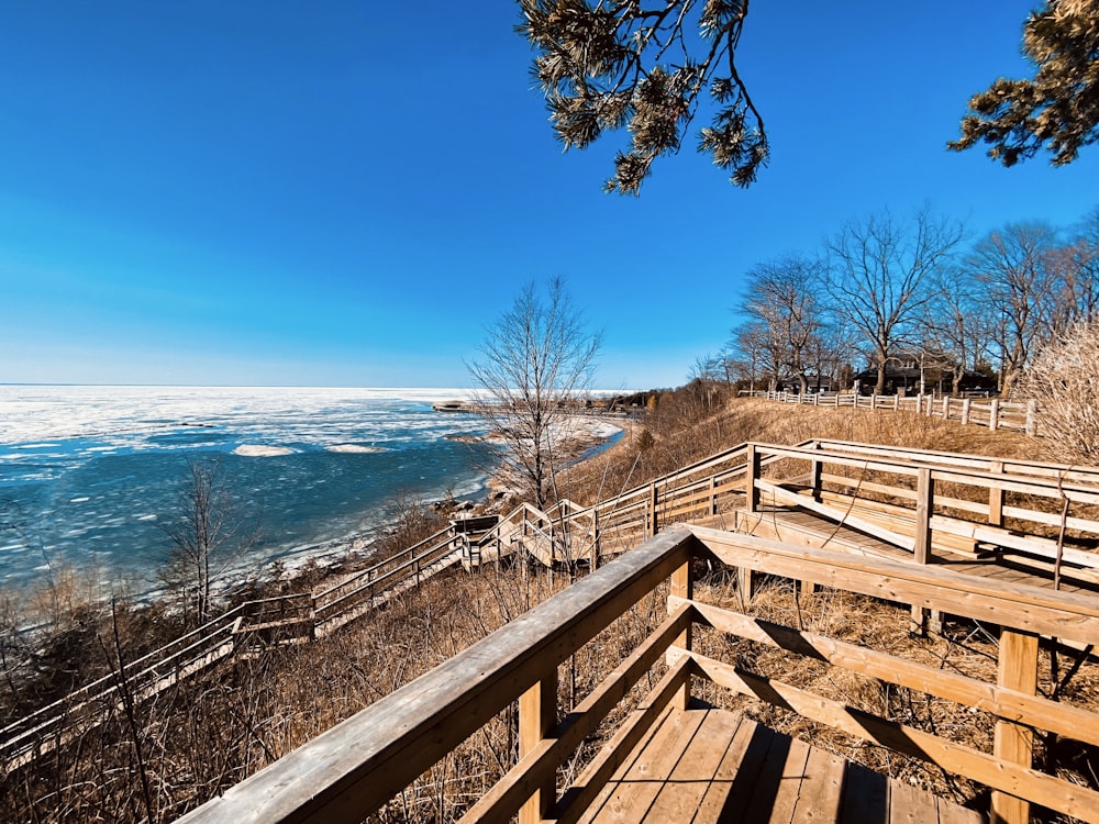 a wooden deck overlooks the water and beach