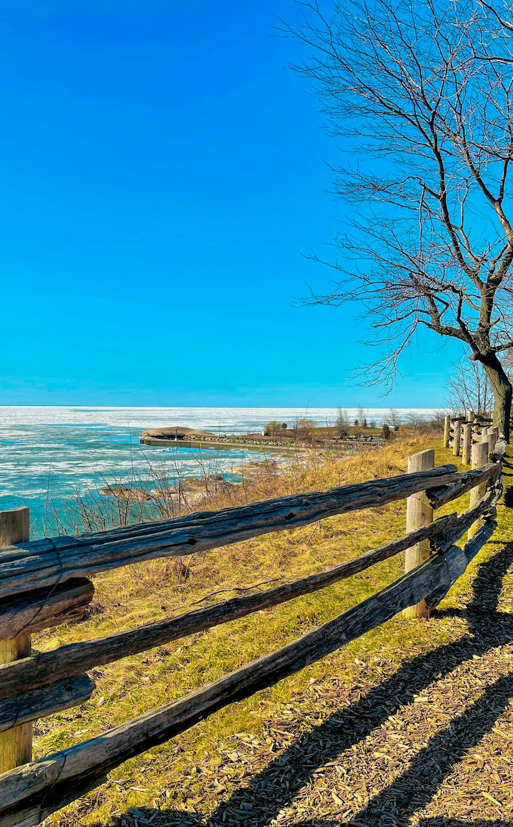 a wooden fence sitting next to a body of water