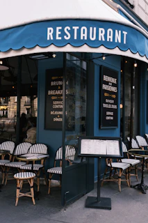 the outside of a restaurant with tables and chairs