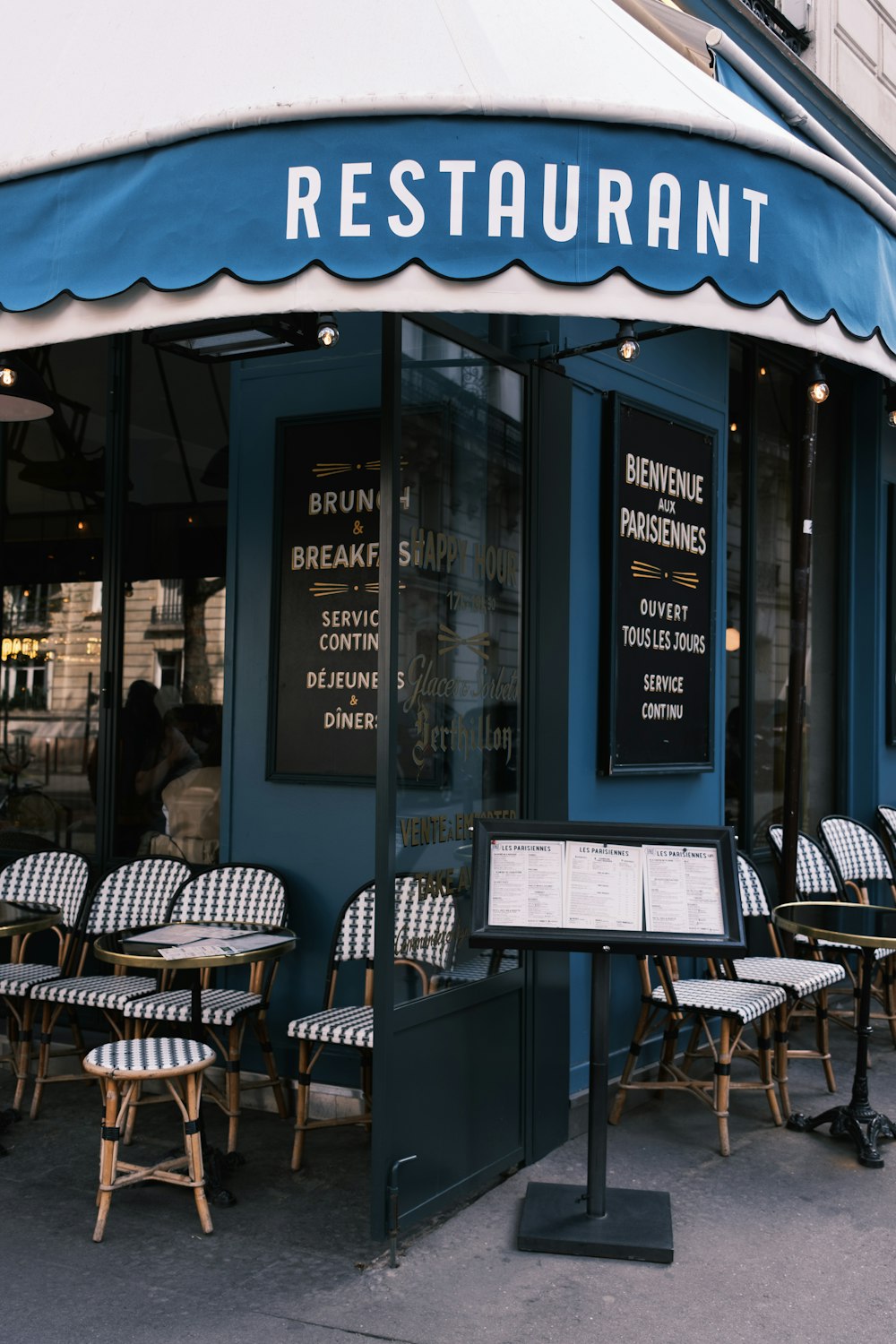 the outside of a restaurant with tables and chairs