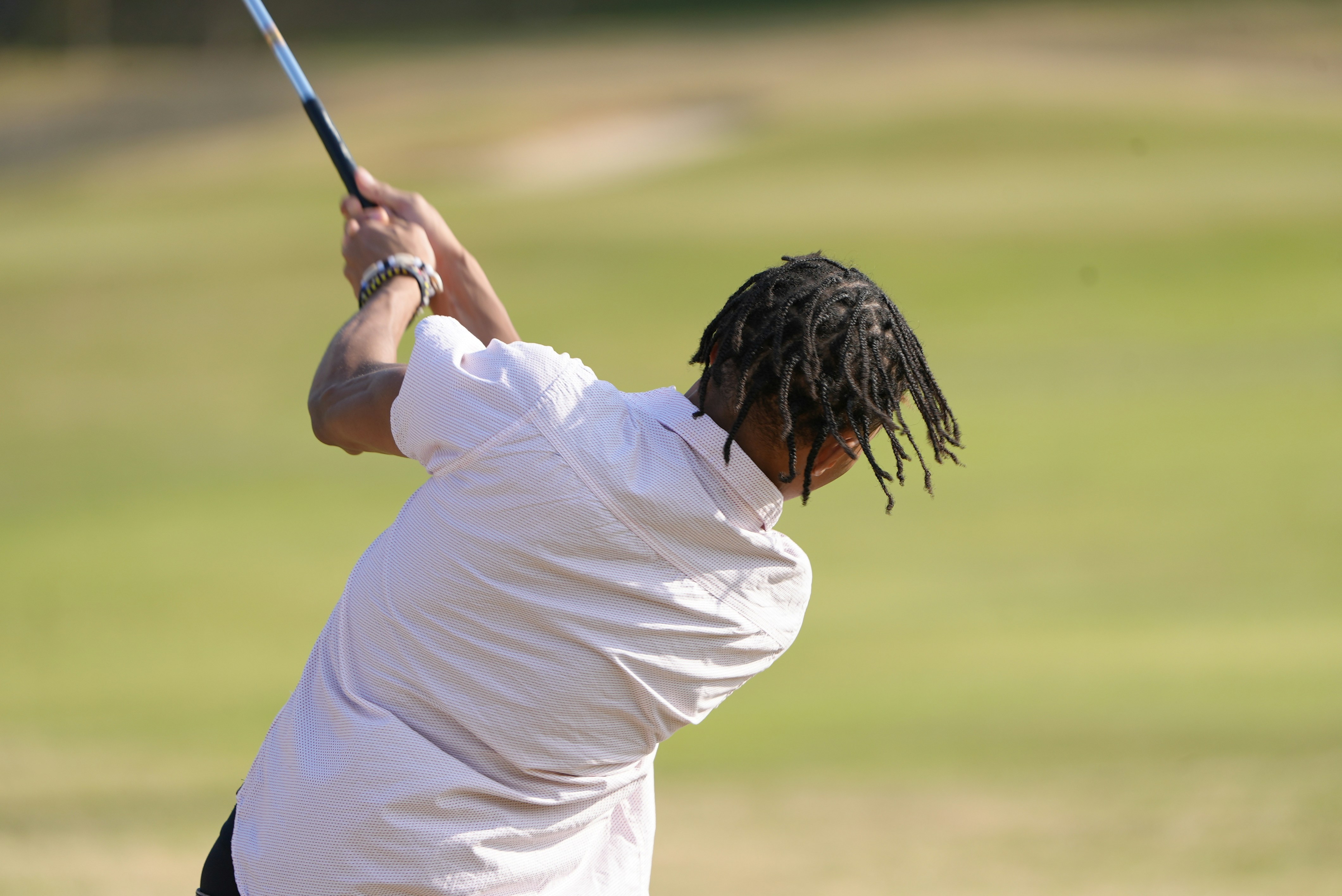 Foto Un hombre con rastas balanceando un palo de golf Imagen Golf