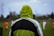 A woman dressed warmly and stylishly watches a youth soccer game from the sidelines.
