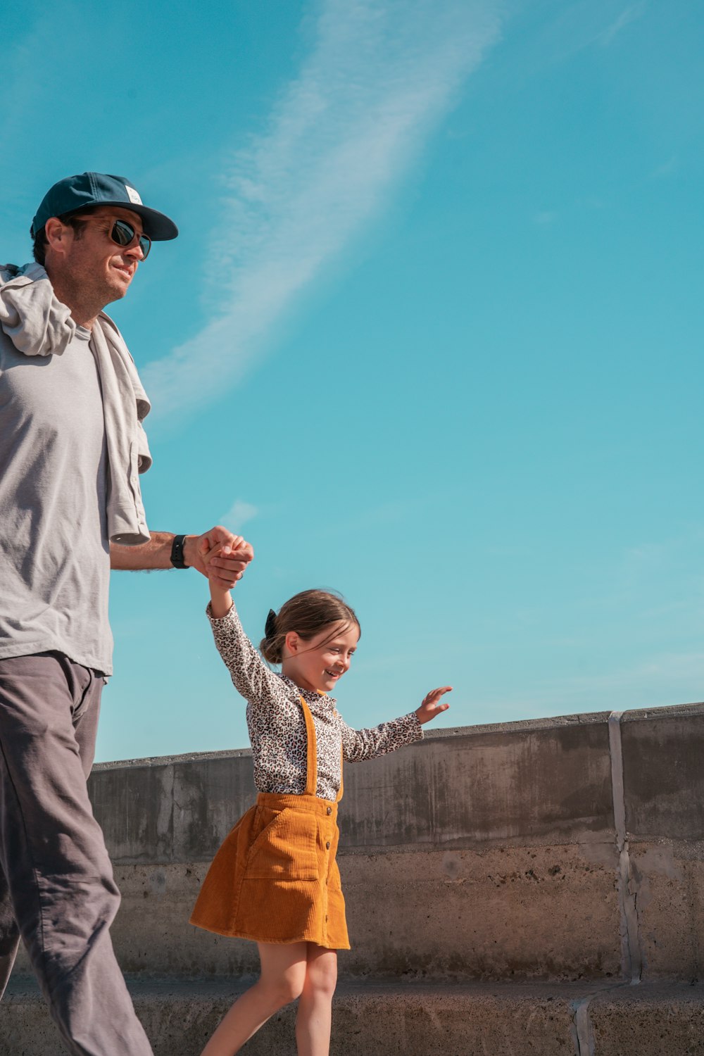 a man and a little girl are walking together