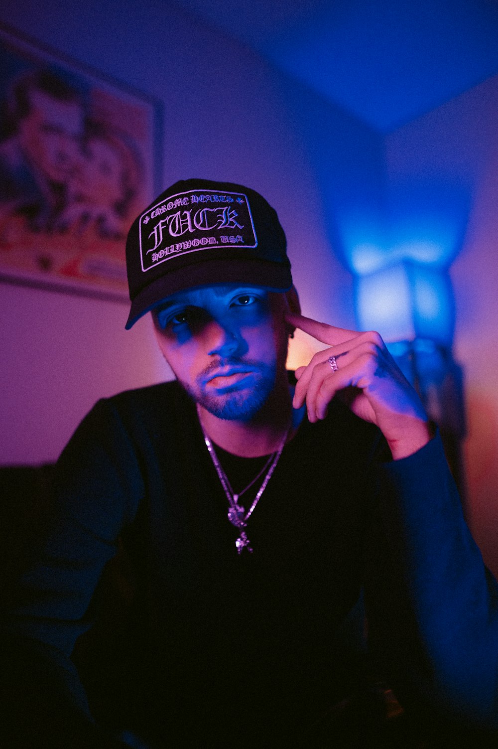 a man wearing a hat sitting in a room