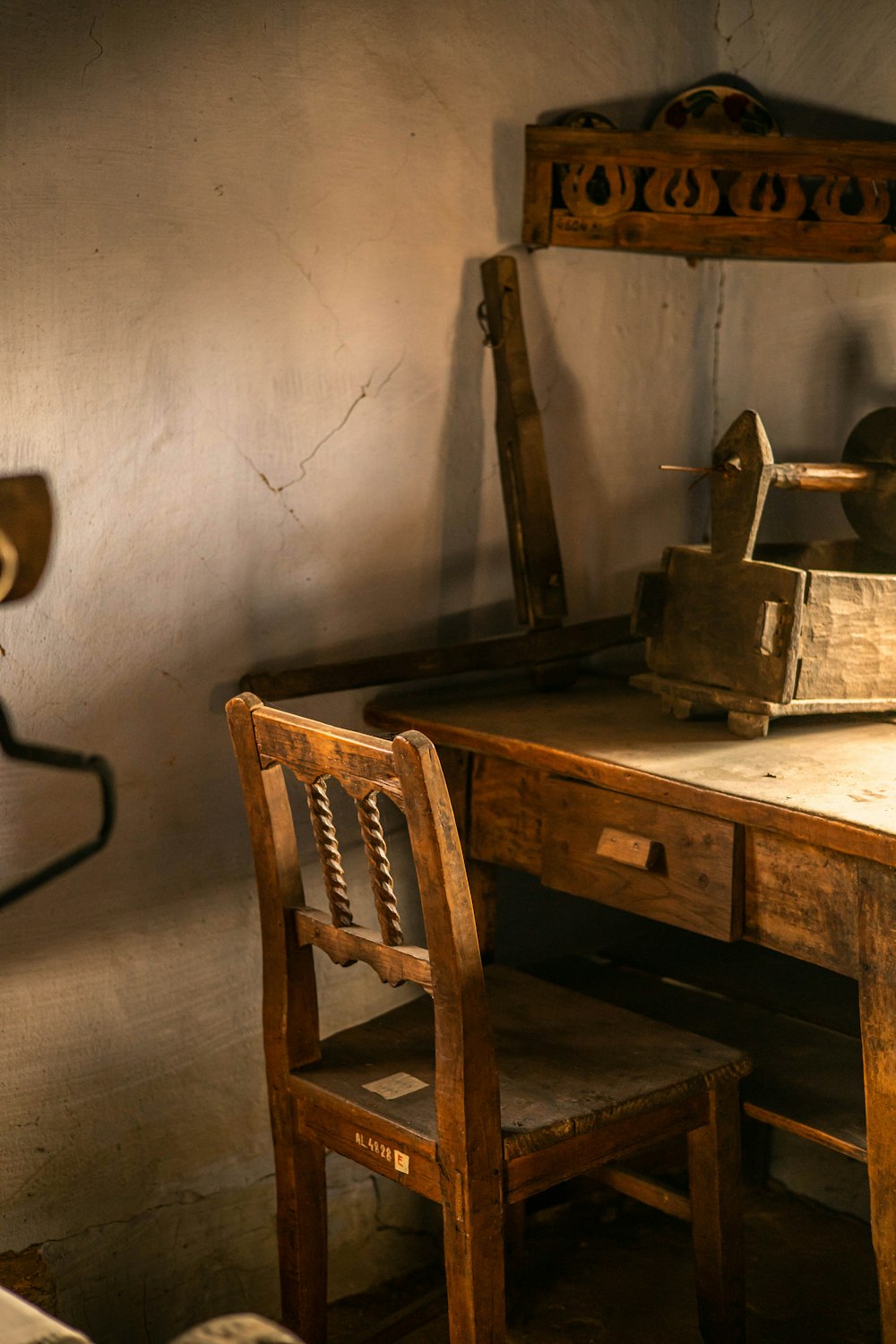 an old wooden desk with a chair and a lamp