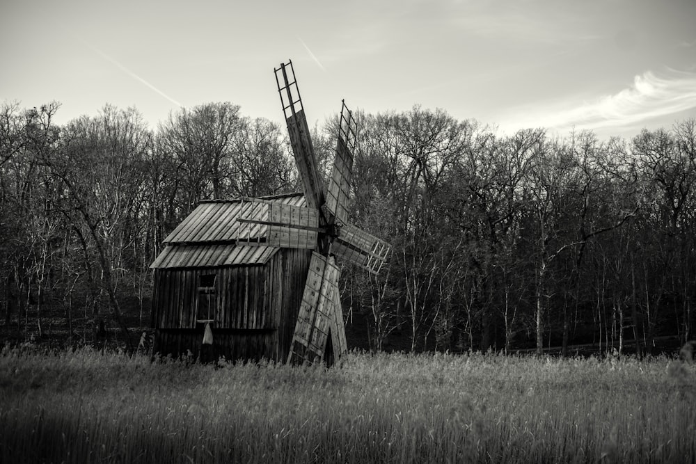 a black and white photo of a windmill in a field