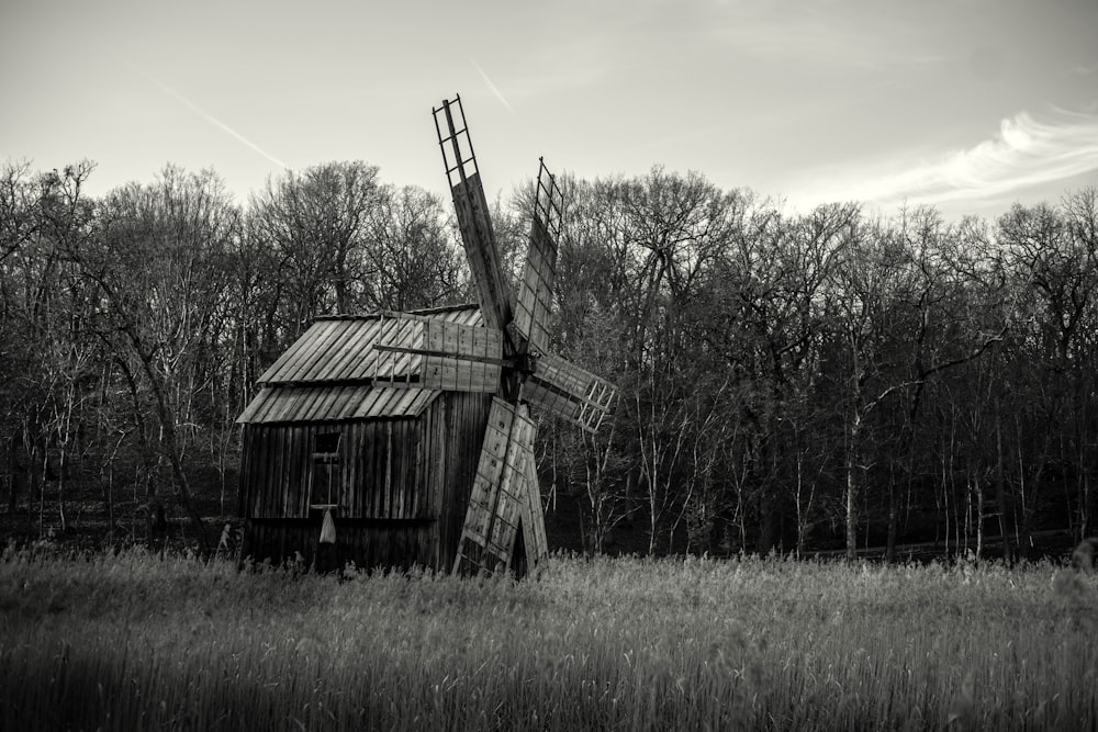 Una foto en blanco y negro de un molino de viento en un campo