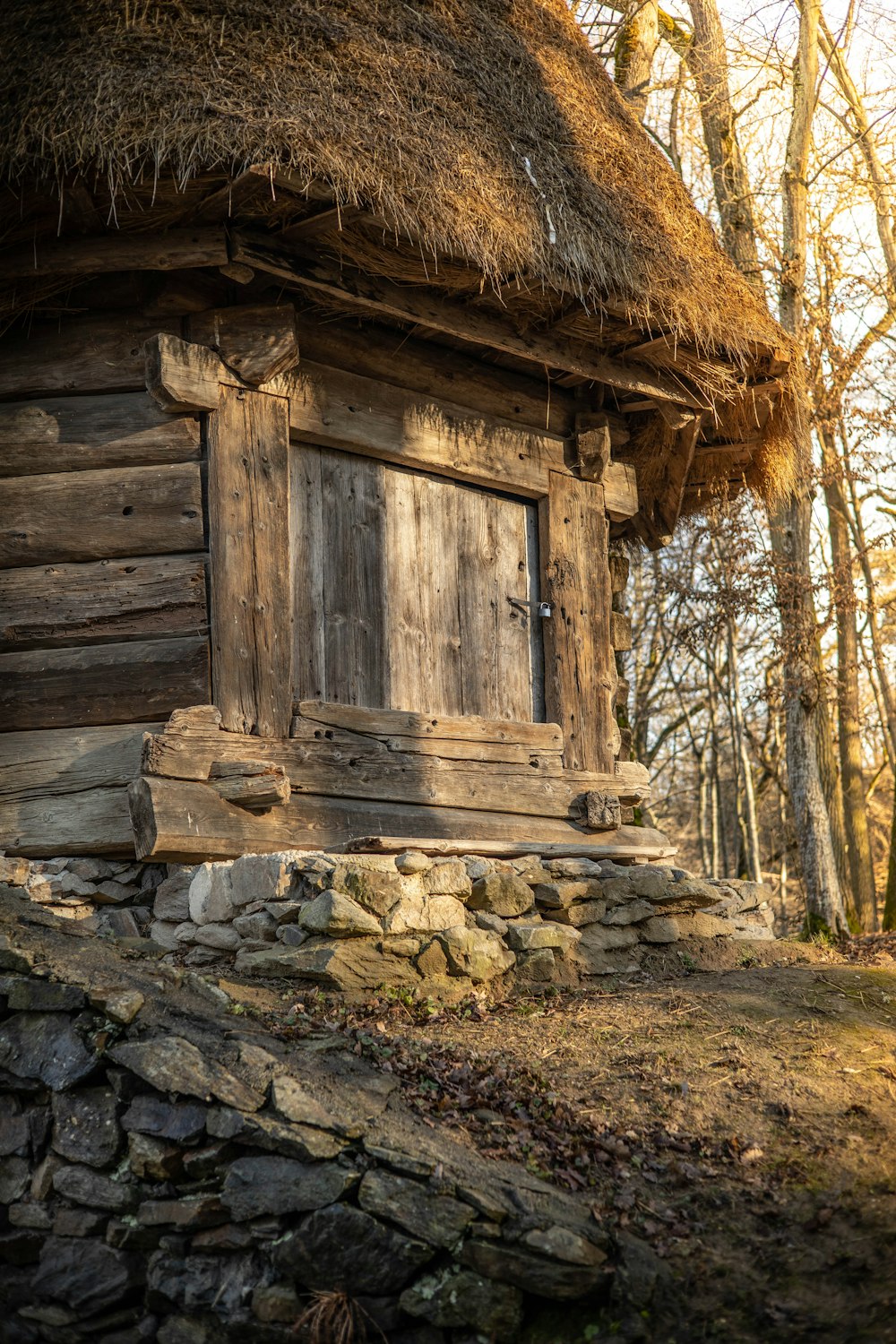 an old log cabin with a thatched roof