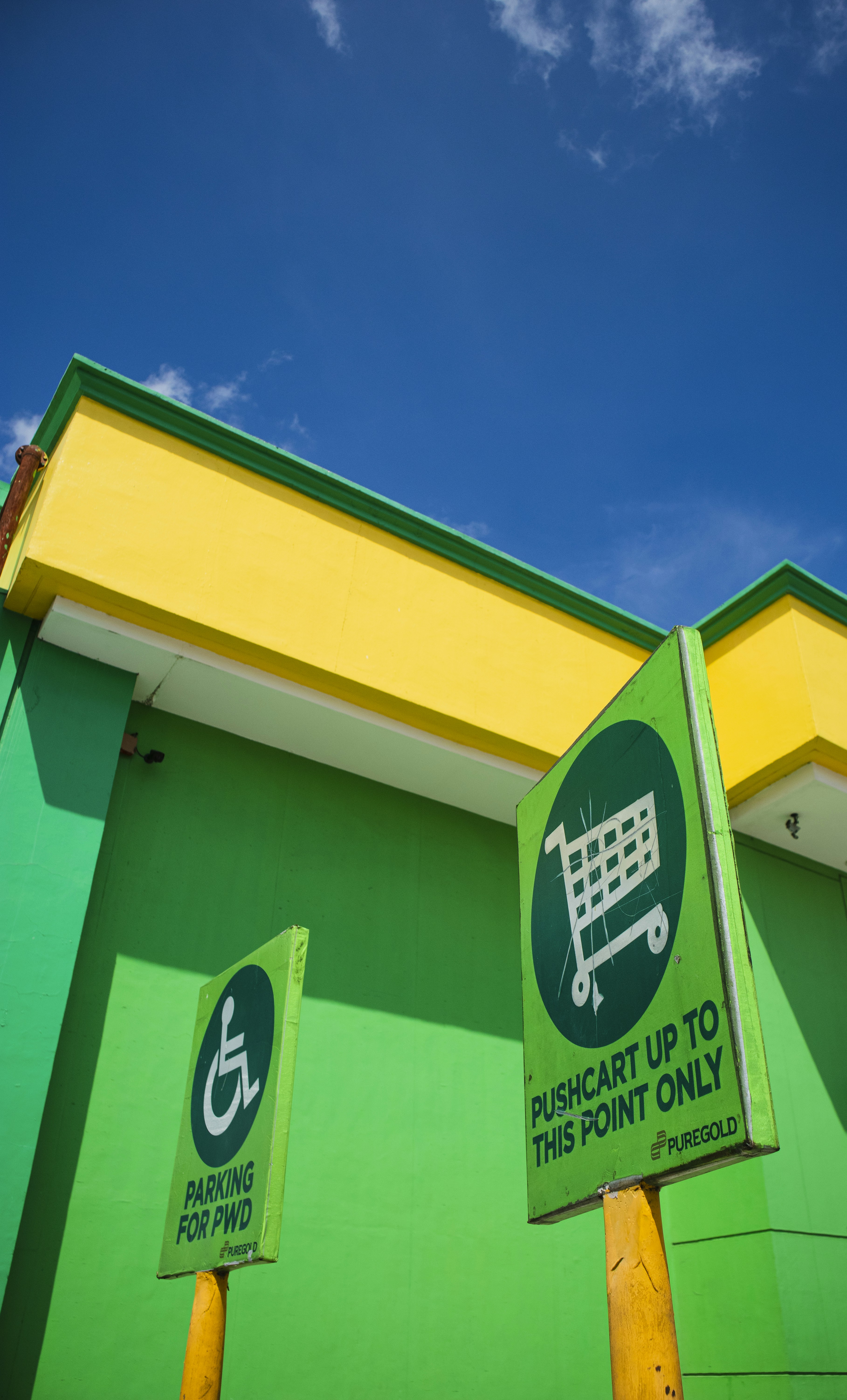 a green and yellow building with a sign that says pushcart up to the