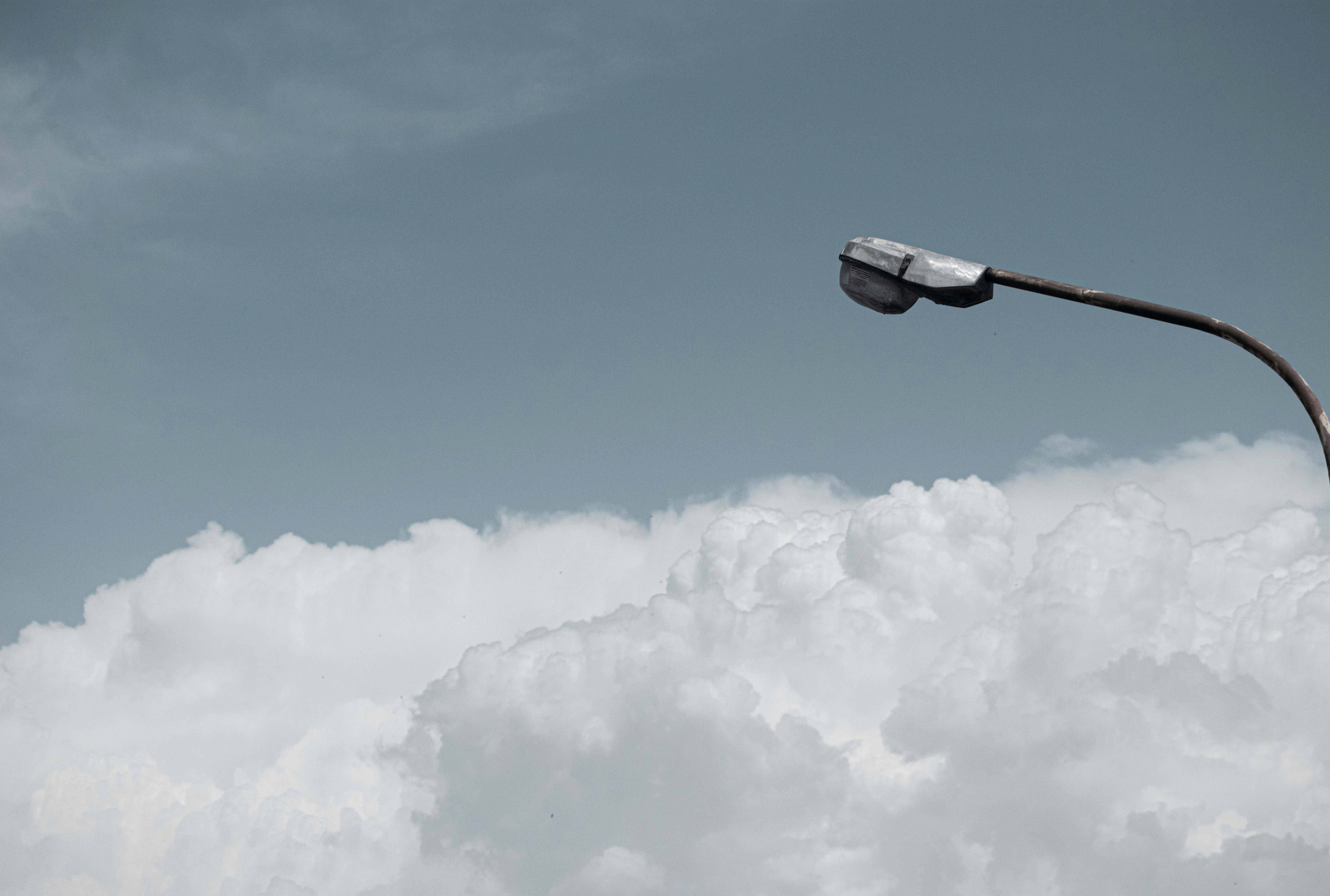 a street light in the middle of a cloudy sky, 