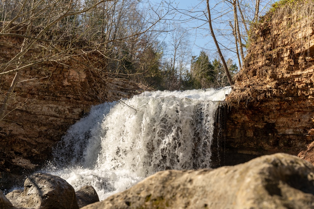 a large waterfall in the middle of a rocky area