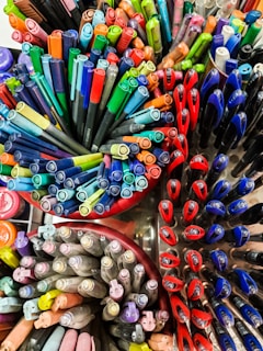 a bunch of different colored pens and markers