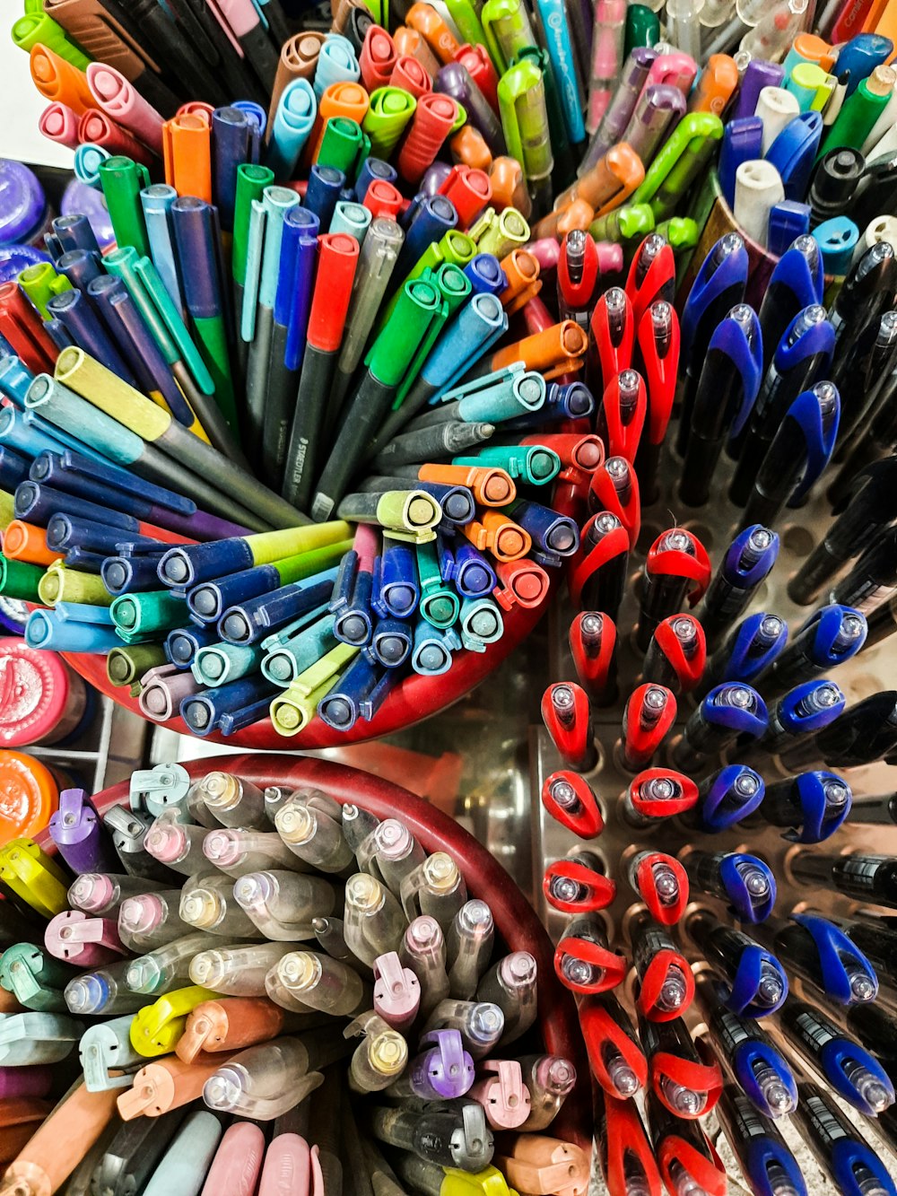 Un montón de bolígrafos y marcadores de diferentes colores