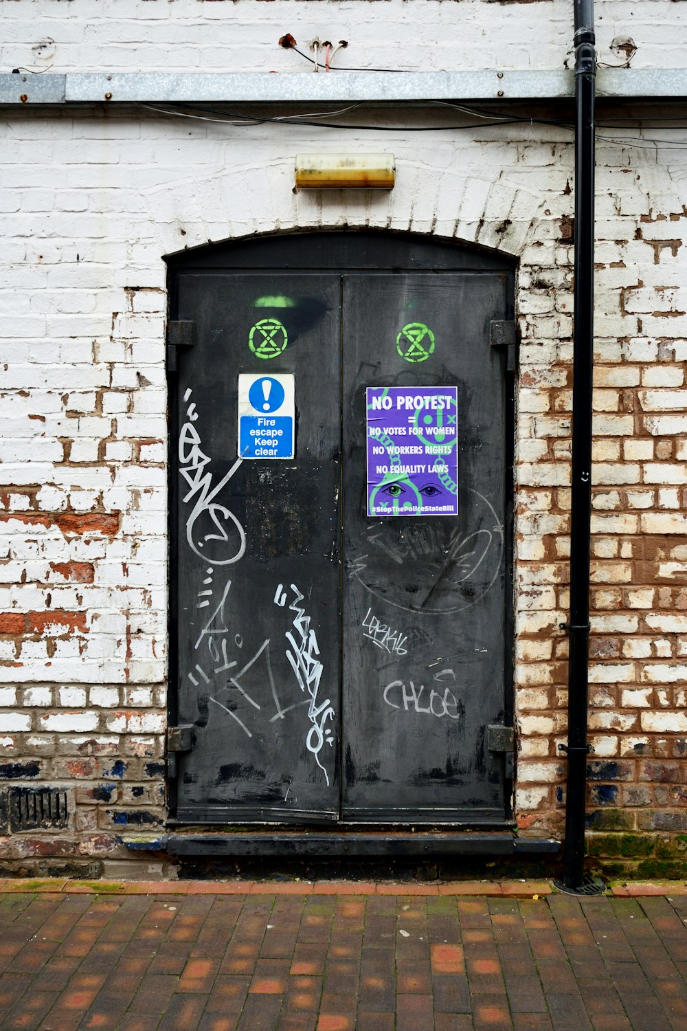 a brick building with graffiti on the doors