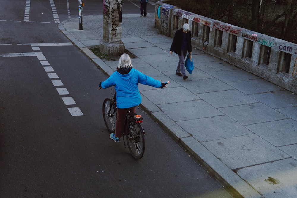 a woman riding a bike down a street