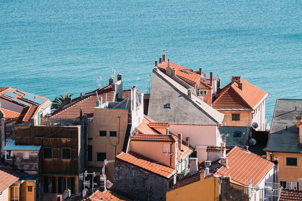 a group of buildings with a body of water in the background