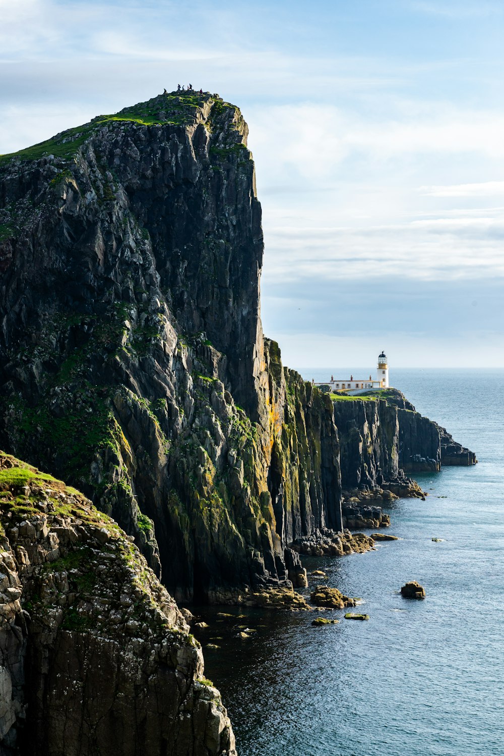 a lighthouse on a cliff overlooking the ocean