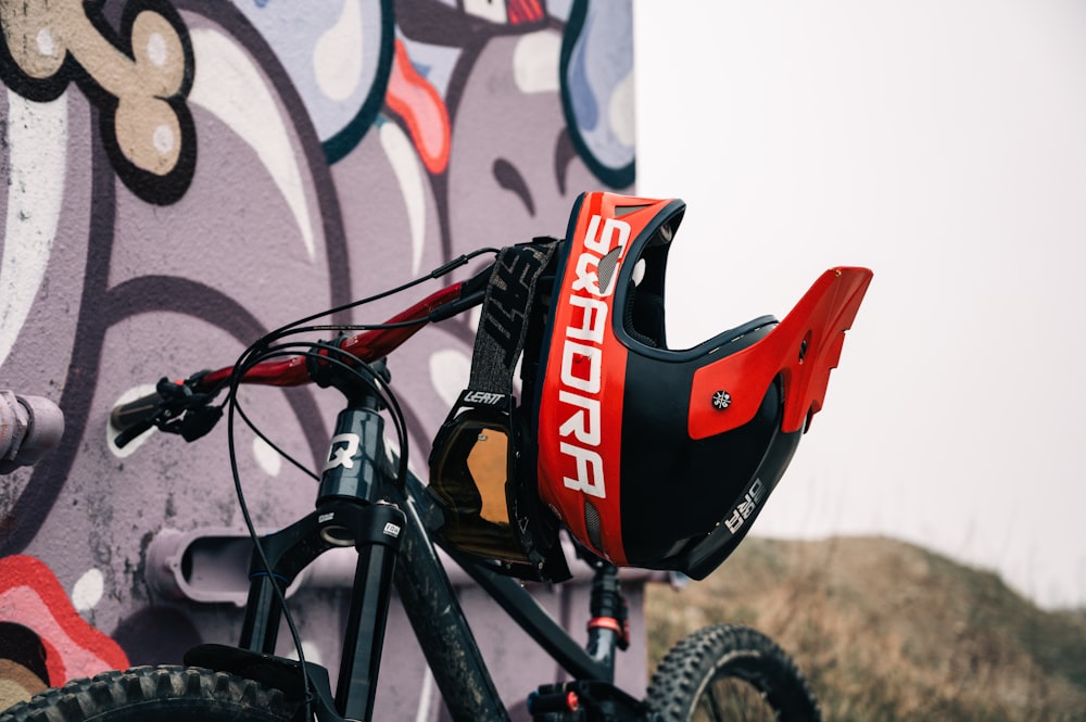 a close up of a bike near a wall with graffiti