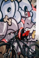 a bicycle parked in front of a graffiti covered wall