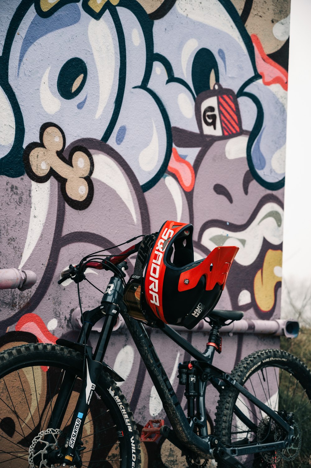 a bicycle parked in front of a graffiti covered wall