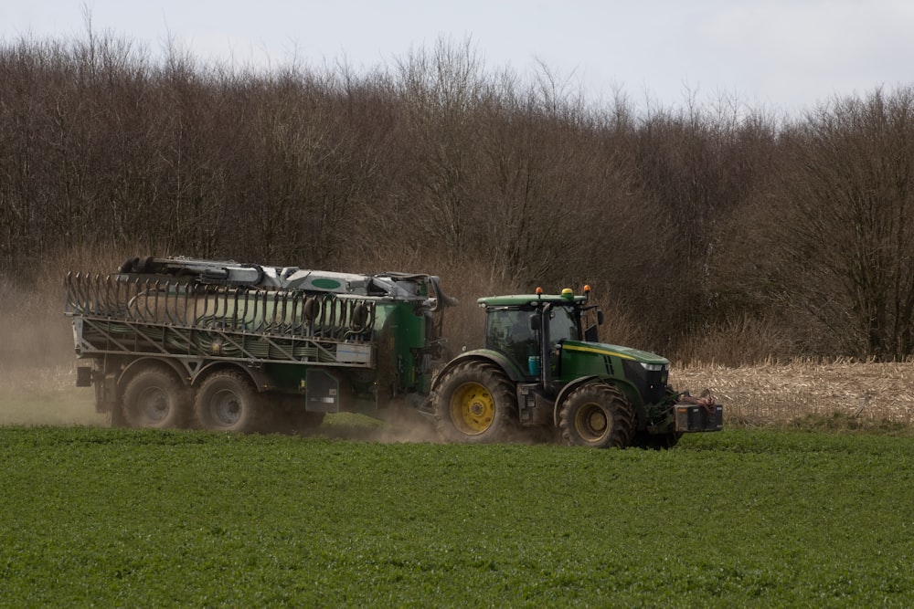 a tractor pulling a trailer behind it in a field