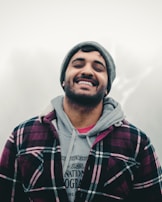 A smiling person stepping outside in a cozy oversized hoodie on a crisp morning.