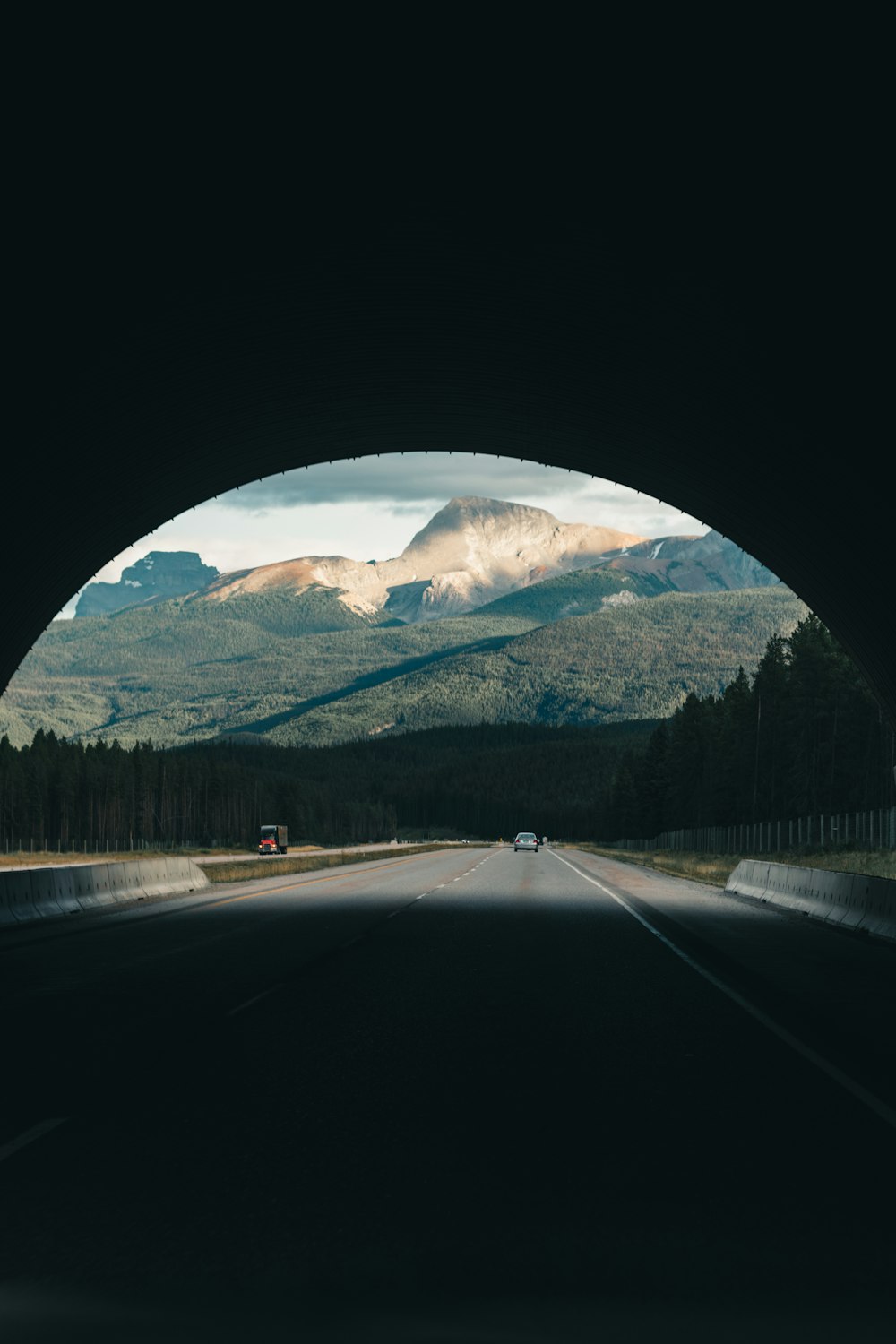 a car driving through a tunnel in the middle of the road