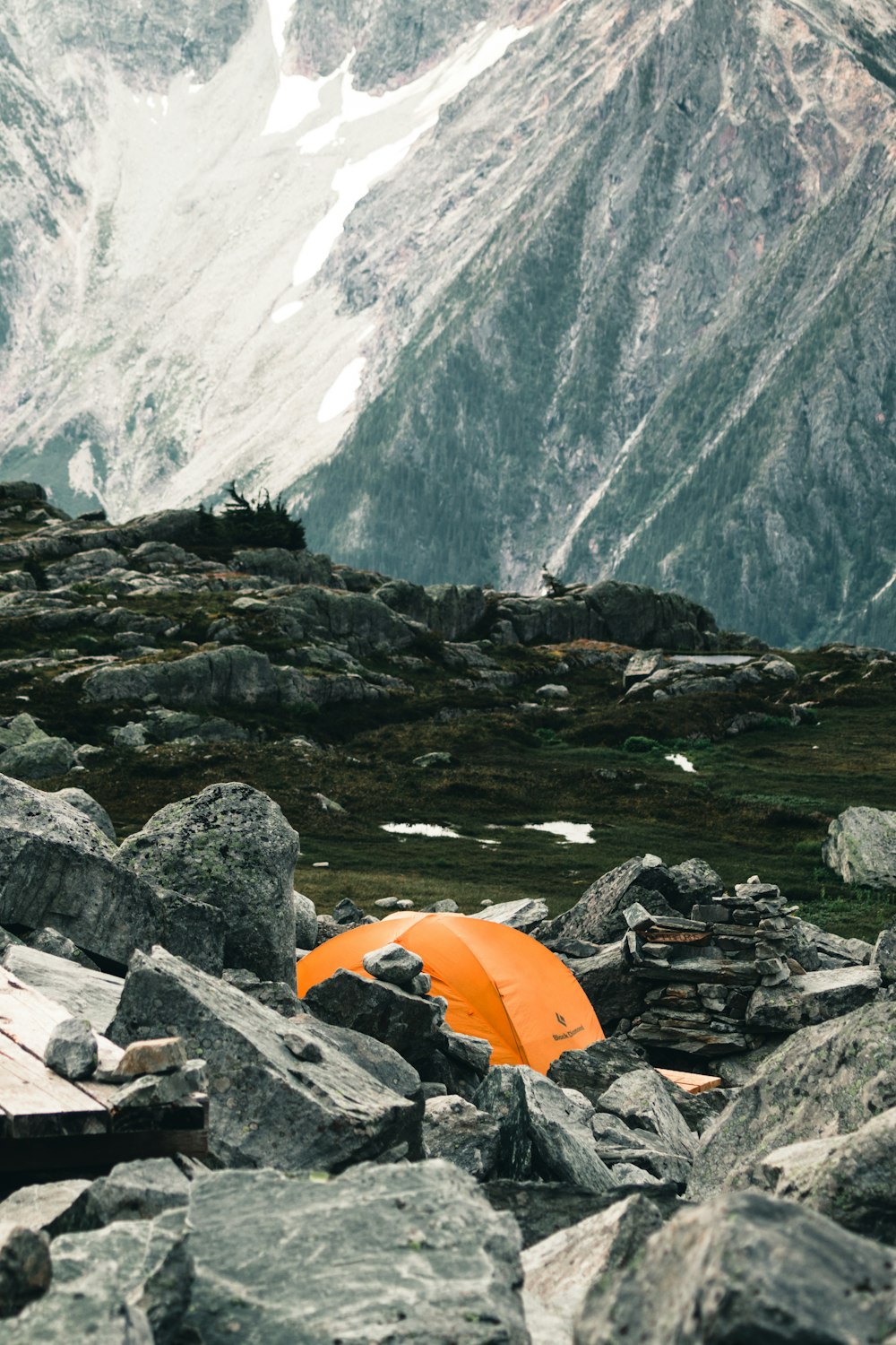 an orange tent sitting on top of a pile of rocks