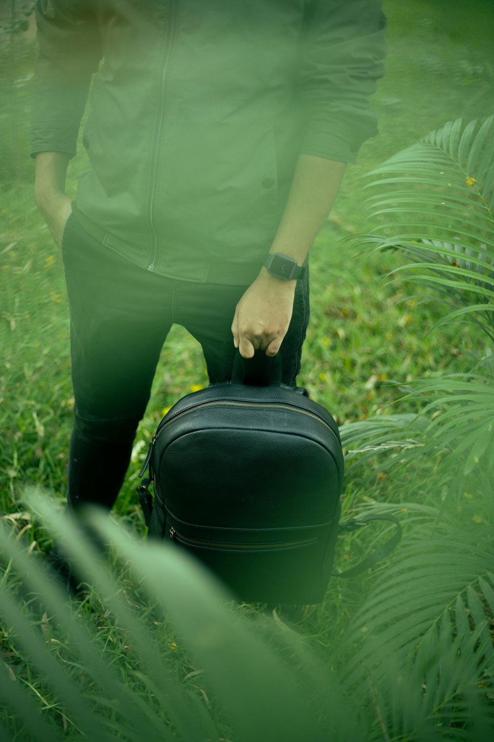 a person standing in a field with a suitcase