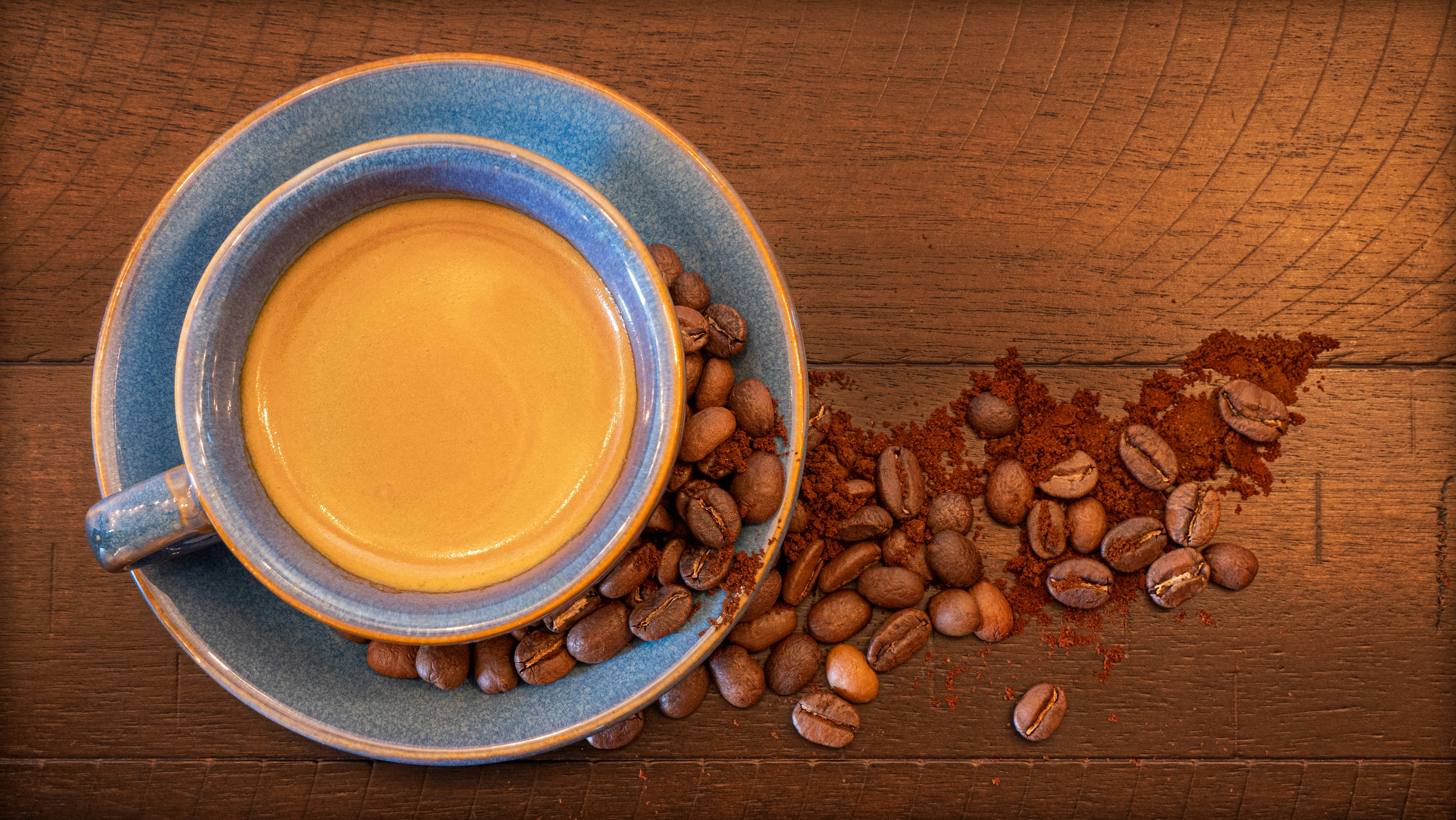 a cup of coffee next to a pile of coffee beans