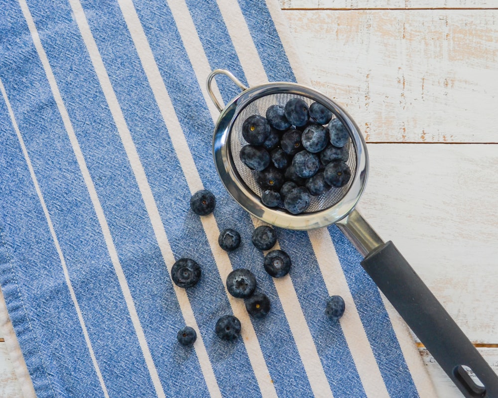 a bowl of blueberries on a blue and white towel