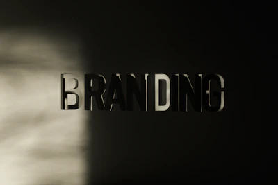 The word 'BRANDING' appears in large, bold, three-dimensional letters against a dark background, with a soft light casting shadows across the left side.
