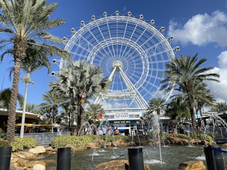 a large ferris wheel sitting next to palm trees