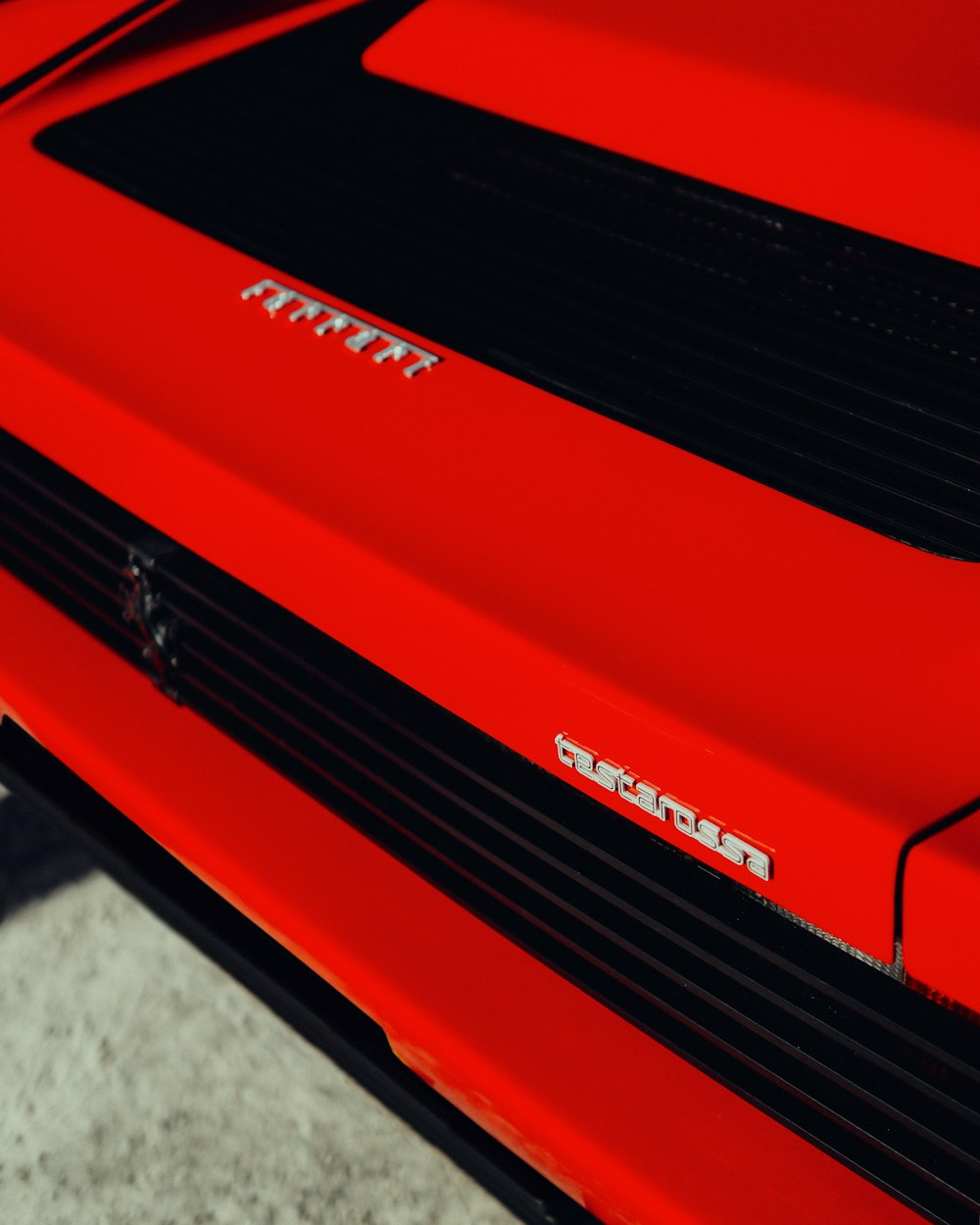 a close up of the front end of a red sports car