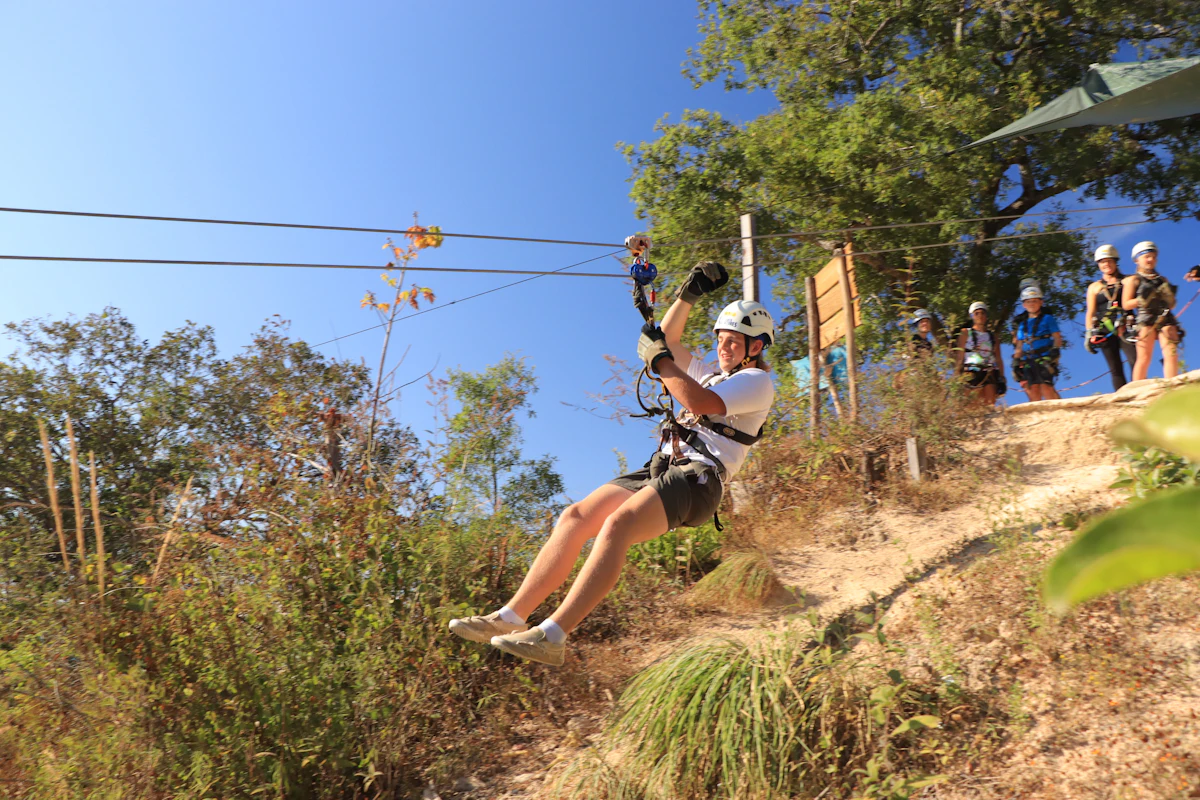 Zip lining across a lush green hillside