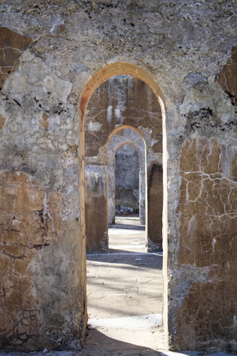 a stone building with an archway leading to another building