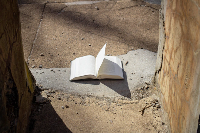 an open book sitting on top of a cement slab