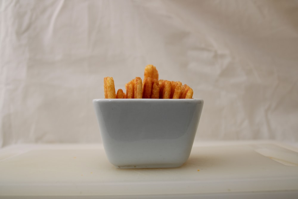 테이블 위에 감자 튀김으로 채워진 흰색 그릇