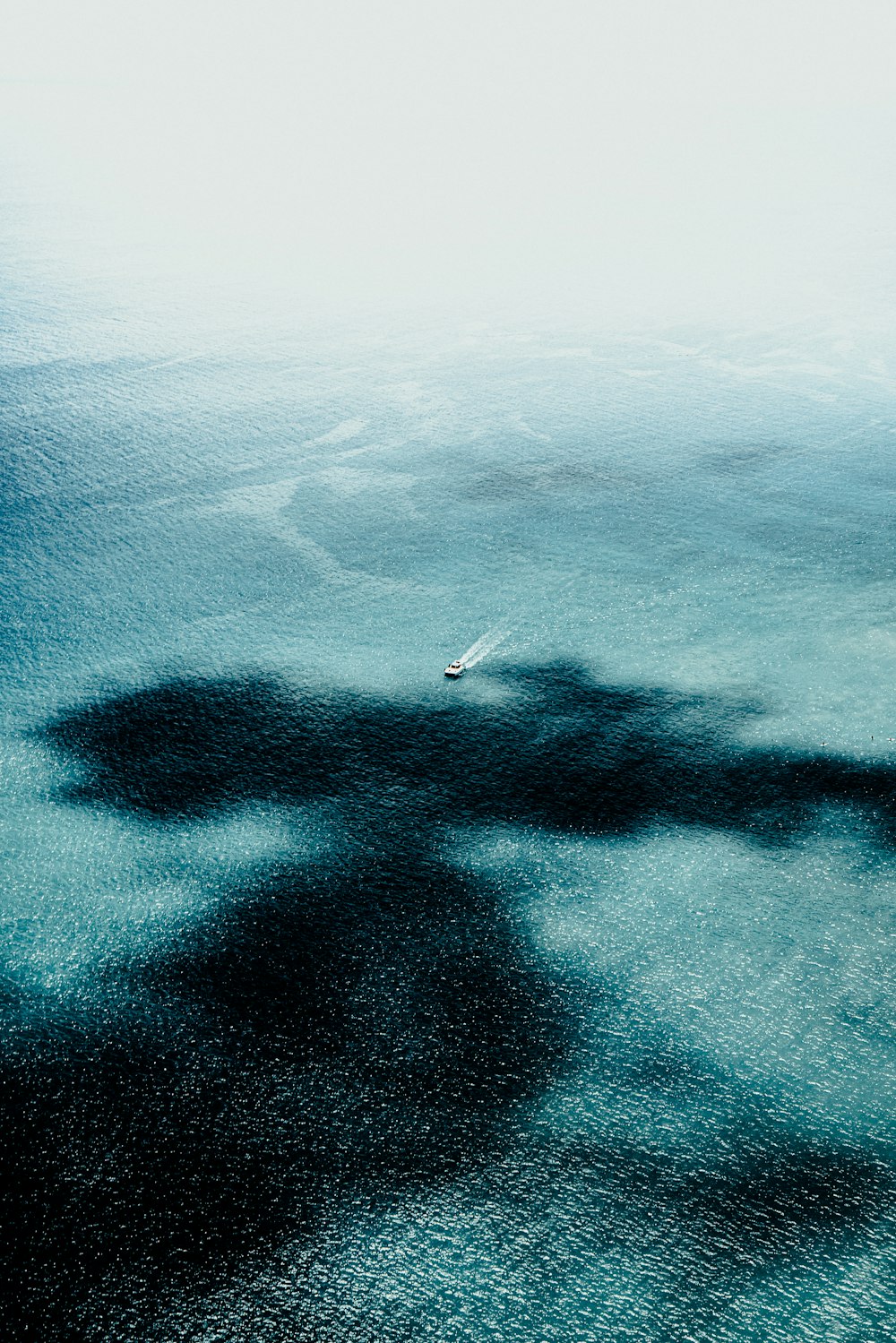 the shadow of a boat on the water