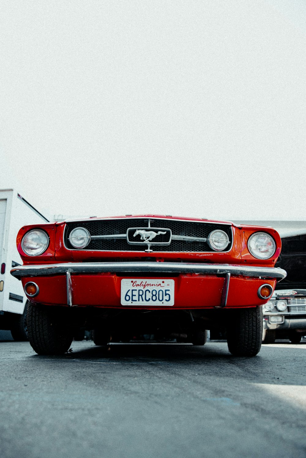 a red car parked next to a white truck