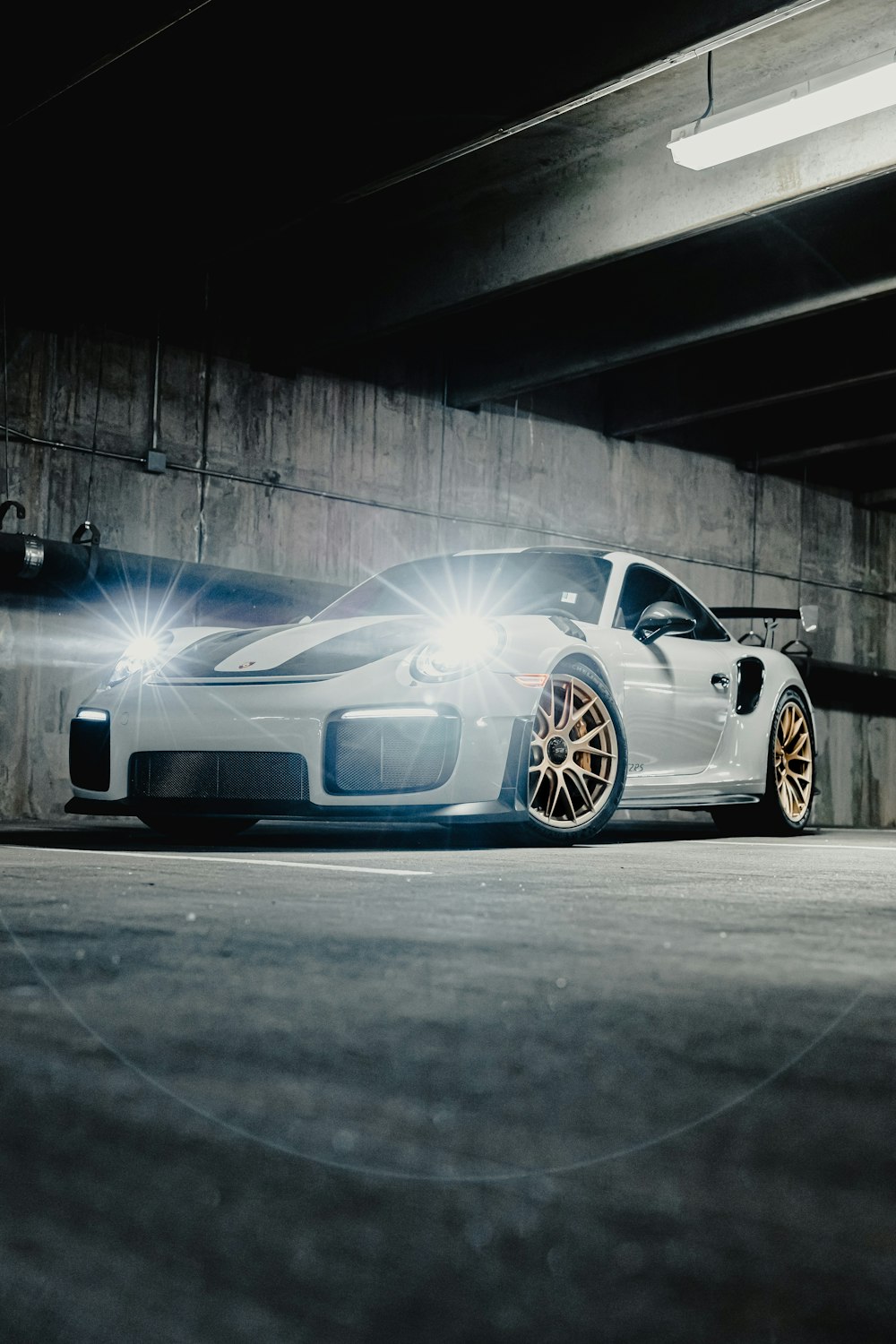 a white sports car parked in a parking garage