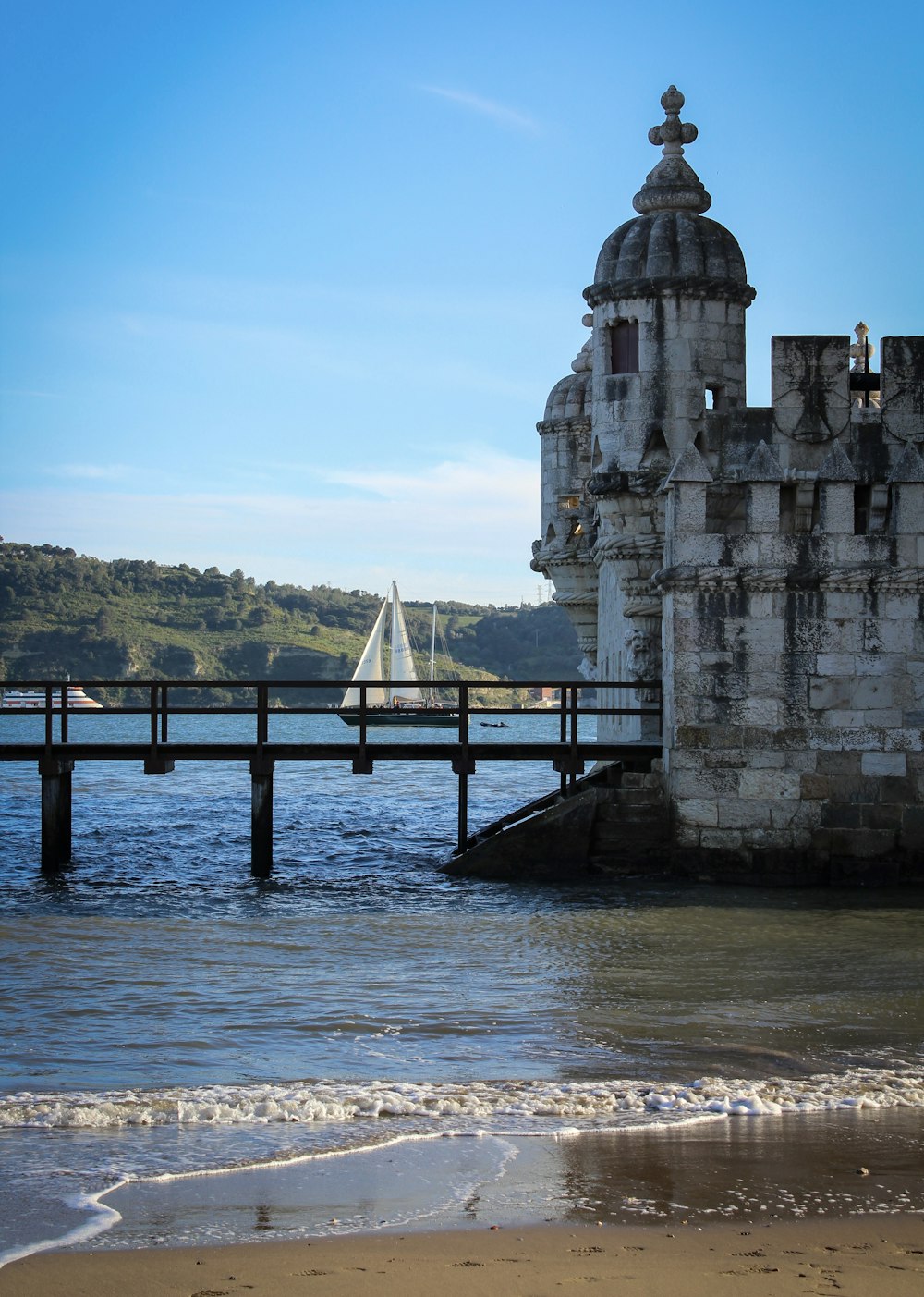 a sailboat is in the water near a pier