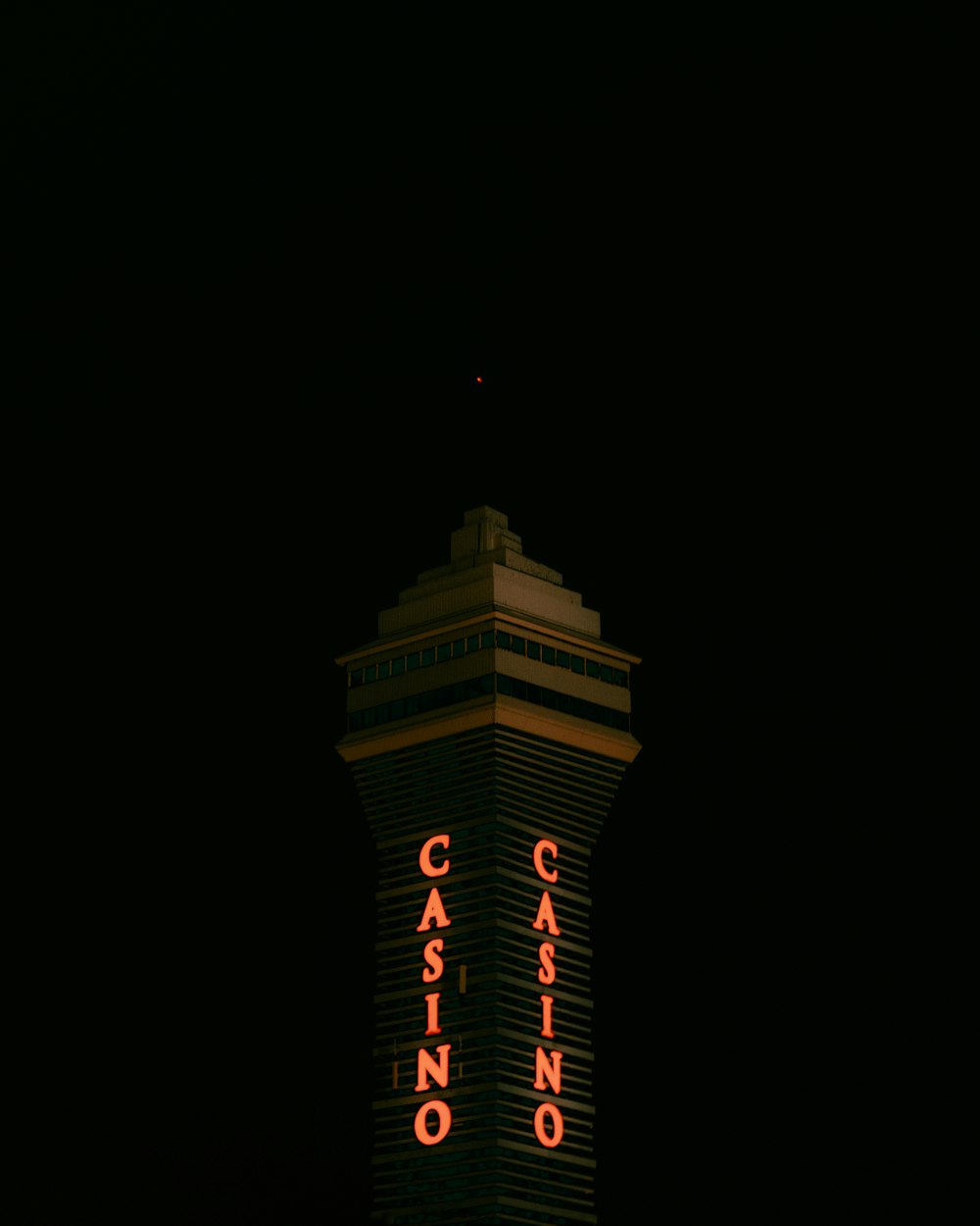 a casino sign lit up at night in the dark
