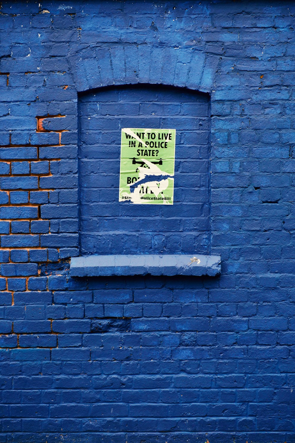 una pared de ladrillo azul con un letrero